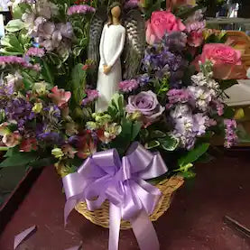 Angel in basket with fresh cut flowers